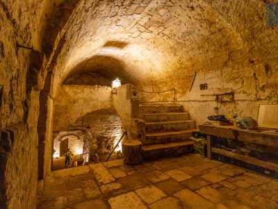 Accediamo prima a un ampio ambiente voltato a botte della famiglia Mastrogiacomo, proprietaria di una parte del fabbricato. Questa stanza, cos� come il resto delle gallerie, � dotata di faretti che emanano una luce calda e soffus